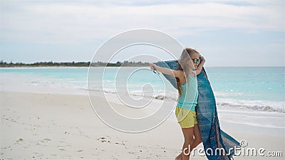 La bambina ha molto divertimento sulla spiaggia Il bambino gode della vacanza della spiaggia con il pareo stock footage La bambina ha molto divertimento sulla spiaggia Il bambino gode della vacanza della spiaggia con il pareo stock footage