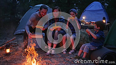 La cena vicino alle fiamme sulla natura, famiglia della famiglia mangia il cereale con sale, viaggio accampantesi, la mamma, papà stock footage La cena vicino alle fiamme sulla natura, famiglia della famiglia mangia il cereale con sale, viaggio accampantesi, la mamma, papà stock footage
