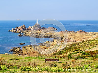 La Corbiere Lighthouse on the rocky coast of Jersey Island Stock Photo