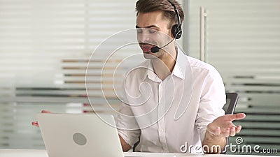 La cuffia avricolare d'uso di Telemarketer che esamina il computer portatile rende ad affare la video chiamata stock footage La cuffia avricolare d'uso di Telemarketer che esamina il computer portatile rende ad affare la video chiamata stock footage