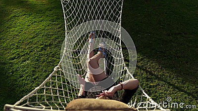 La donna raffredda nell'amaca sul tramonto, la vacanza ed il rilassamento, la natura e la ricreazione video d archivio La donna raffredda nell'amaca sul tramonto, la vacanza ed il rilassamento, la natura e la ricreazione video d archivio