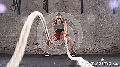 La femelle sportive activement dans un gymnase s'exerce avec des cordes de bataille pendant sa séance d'entraînement croisée de f banque de vidéos La femelle sportive activement dans un gymnase s'exerce avec des cordes de bataille pendant sa séance d'entraînement croisée de f banque de vidéos