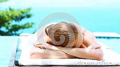 La femme de sourire sur la station thermale enfoncent à côté de la piscine La femme de sourire sur la station thermale enfoncent à côté de la piscine