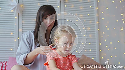 La femme tisse des tresses avec peu de fille sur un lit banque de vidéos La femme tisse des tresses avec peu de fille sur un lit banque de vidéos