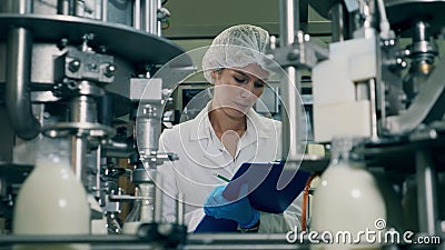 La femme vérifie les bouteilles de lait sur un convoyeur industriel de nourriture et de boissons de plantes clips vidéos La femme vérifie les bouteilles de lait sur un convoyeur industriel de nourriture et de boissons de plantes clips vidéos