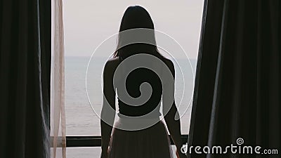 La jeune belle femme décontractée heureuse ouvre des rideaux en fenêtre dans la chambre d'hôtel d'apprécier le mouvement lent de banque de vidéos La jeune belle femme décontractée heureuse ouvre des rideaux en fenêtre dans la chambre d'hôtel d'apprécier le mouvement lent de banque de vidéos