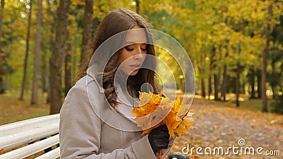 La jeune femme avec du charme regarde les feuilles en baisse, et attend son M. droite clips vidéos La jeune femme avec du charme regarde les feuilles en baisse, et attend son M. droite clips vidéos