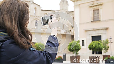 La mujer joven está tomando imágenes de un edificio en Valencia con su teléfono metrajes La mujer joven está tomando imágenes de un edificio en Valencia con su teléfono metrajes