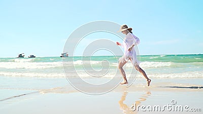La mujer rubia joven con el sombrero y la túnica blanca se mueve en la playa tailandesa almacen de video La mujer rubia joven con el sombrero y la túnica blanca se mueve en la playa tailandesa almacen de video