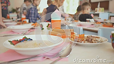 La preparazione per un pranzo irrompe l'asilo I bambini si siedono alla tavola con cibo cotto Il Russo stock footage La preparazione per un pranzo irrompe l'asilo I bambini si siedono alla tavola con cibo cotto Il Russo stock footage