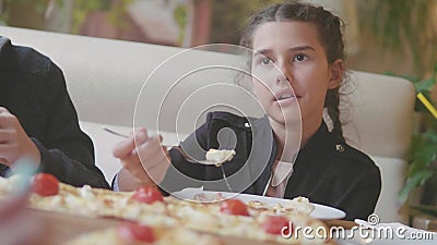 La ragazza teenager mangia la pizza in video di movimento lento del caffè i bambini mangiano la pizza una pizza deliziosa società stock footage La ragazza teenager mangia la pizza in video di movimento lento del caffè i bambini mangiano la pizza una pizza deliziosa società stock footage