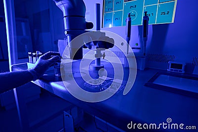 Lab technician cleaning workplace after researching under microscope Stock Photo