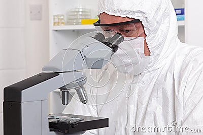 Lab technician looking through a microscope Stock Photo