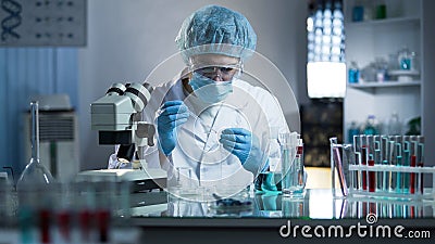 Lab worker dripping sample onto laboratory glass to research cloning process Stock Photo
