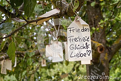 Label with wishes hangs in a tree Stock Photo