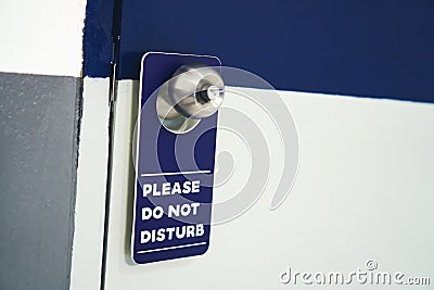 Label please do not disturb white with blue hang on the door in hotel. Stock Photo