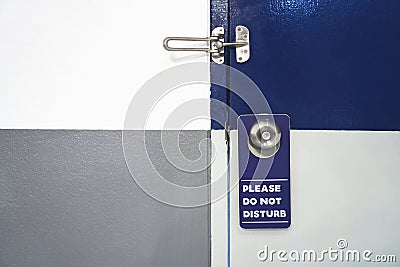 Label please do not disturb white with blue hang on the door in hotel. Stock Photo