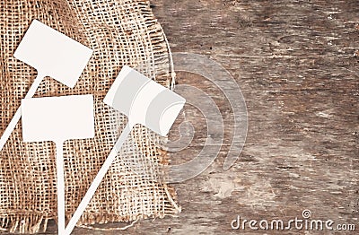 Labels-markers for plants lie on burlap, on a wooden brown background., Top view Stock Photo