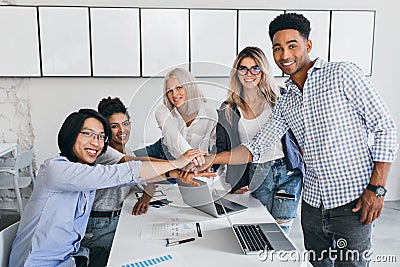 Labor collective of young international professionals ready to team work. Indoor portrait of short-haired blonde girl Stock Photo
