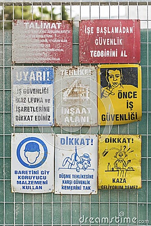 Labor health and work safety warning signs in front of a building under construction , close up Editorial Stock Photo