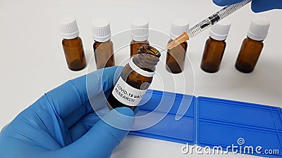 Laboratory assistant filling the syringe with Covid-19 vaccine from a vial Stock Photo