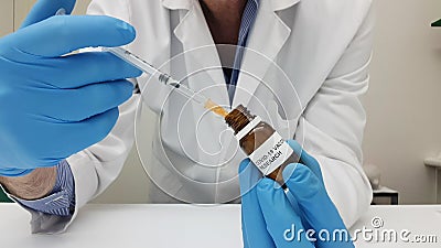 Laboratory assistant filling the syringe with Covid-19 vaccine from a vial Stock Photo