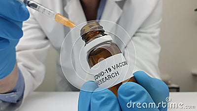 Laboratory assistant filling the syringe with Covid-19 vaccine from a vial Stock Photo