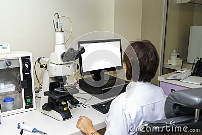 Laboratory assistant performs a blood test in a modern laboratory on the analyzer Editorial Stock Photo