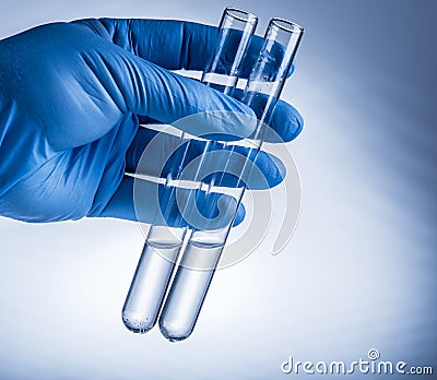 Laboratory beakers in analyst's hand in plastic glove Stock Photo