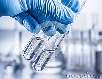 Laboratory beakers in analyst`s hand. Stock Photo