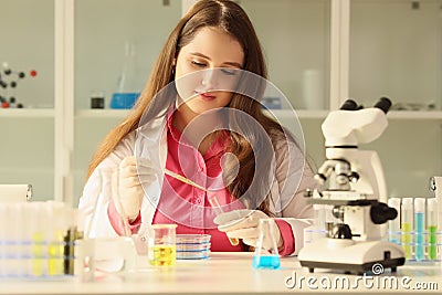 Laboratory employee pours urine into test tube using pipette Stock Photo