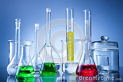 Laboratory equipment, bottles, flasks with color liquid on blue background Stock Photo