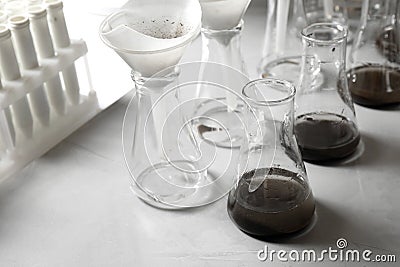 Laboratory glassware with soil extracts and funnels Stock Photo