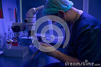 Laboratory technician preparing sample to examine under microscope Stock Photo