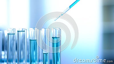 Laboratory worker pouring blue liquid in tubes, cleaning detergent production Stock Photo
