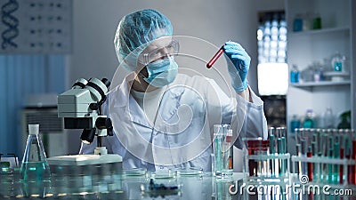 Laboratory worker studying blood samples to detect pathologies, medical research Stock Photo
