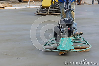 Laborer performing polishing cement screed foundation on the construction site for new house Stock Photo