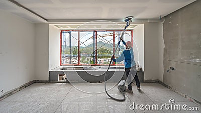 Laborer performing and polishing sand and cement screed wall Stock Photo