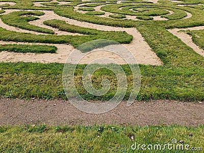 Labyrinth of green grass and sand in the garden. Stock Photo