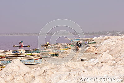 LAC ROSE, SENEGAL - NOVEMBER 13, 2019: People harvesting salt on Lac Rose or Lake Retba. Dakar. West Africa. UNESCO World Heritage Editorial Stock Photo