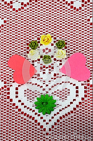 Lace doily with heart on red background with cutout hearts and craft flowers forming a Valenine design Stock Photo