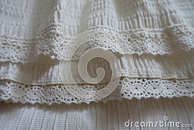 Lace ribbons stitched to frills on hem of skirt Stock Photo