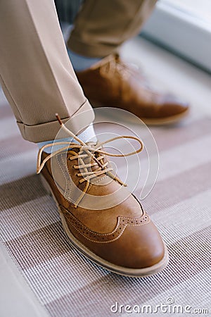 Laced brown brogues on the groom's legs. Close-up Stock Photo