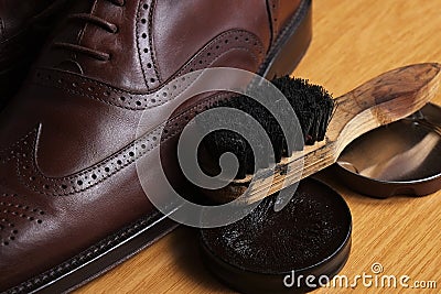 Laced brown leather classic Brogue shoes with polishing cream and brush Stock Photo