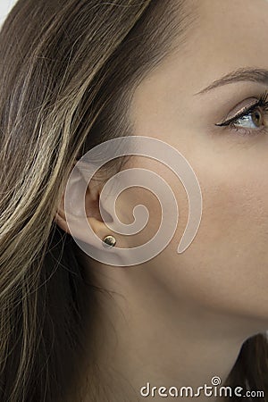 Lack of earlobe. A beautiful woman with an ingrown earlobe. The face of a beautiful girl close-up. Her earlobe is Stock Photo