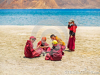 Group of Little buddhist monks wearing Covid mask near beautiful Pangong lake Editorial Stock Photo