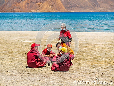 Group of Little buddhist monks wearing Covid mask near beautiful Pangong lake Editorial Stock Photo