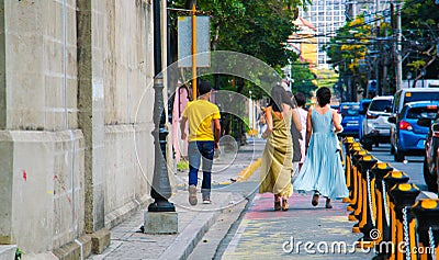 Ladies in gowns walking on the street Editorial Stock Photo