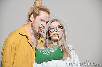 Ladies handbag. Couple holds fashion handbag in mouth. Stock Photo