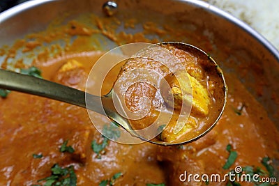 A ladle full of Paneer Butter Masala , a rich and creamy Indian dish made of Paneer or Tofu in tomato and cream gravy Stock Photo